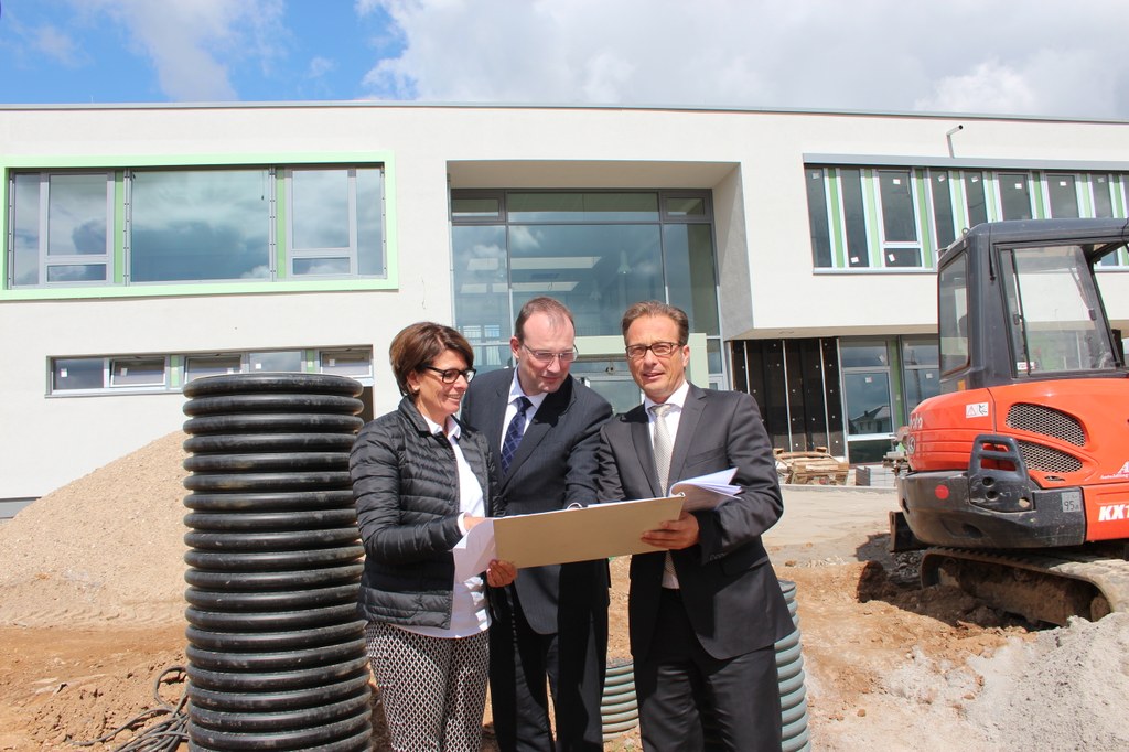 Bürgermeister Reiner Breuer (re.) besucht die Baustelle der neuen Grundschule in Allerheiligen. Andrea Schiefke, Leiterin des Gebäudemanagement Neuss, und Baudezernent Christoph Hölters (Mitte) erläutern Bauweise und Baufortschritt an dem neuen Gebäude. 