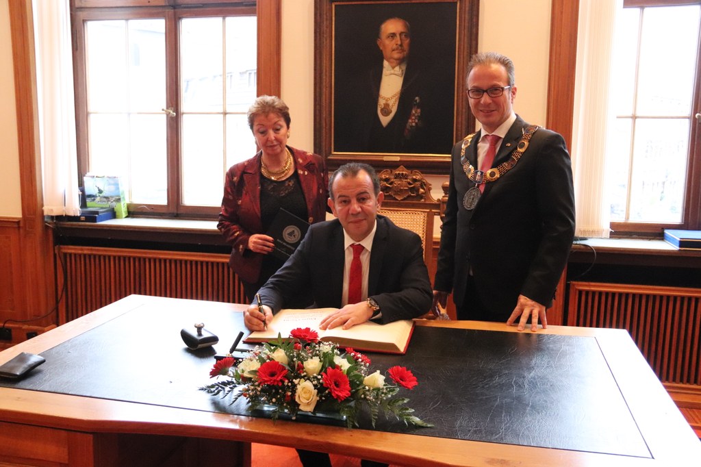 Tanju Özcan, Bürgermeister der befreundeten türkischen Stadt Bolu, trägt sich im Beisein von Bürgermeister Reiner Breuer und Angelika Quiring-Perl, Vorsitzende des Partnerschaftskomitees, in das Goldene Buch ein.