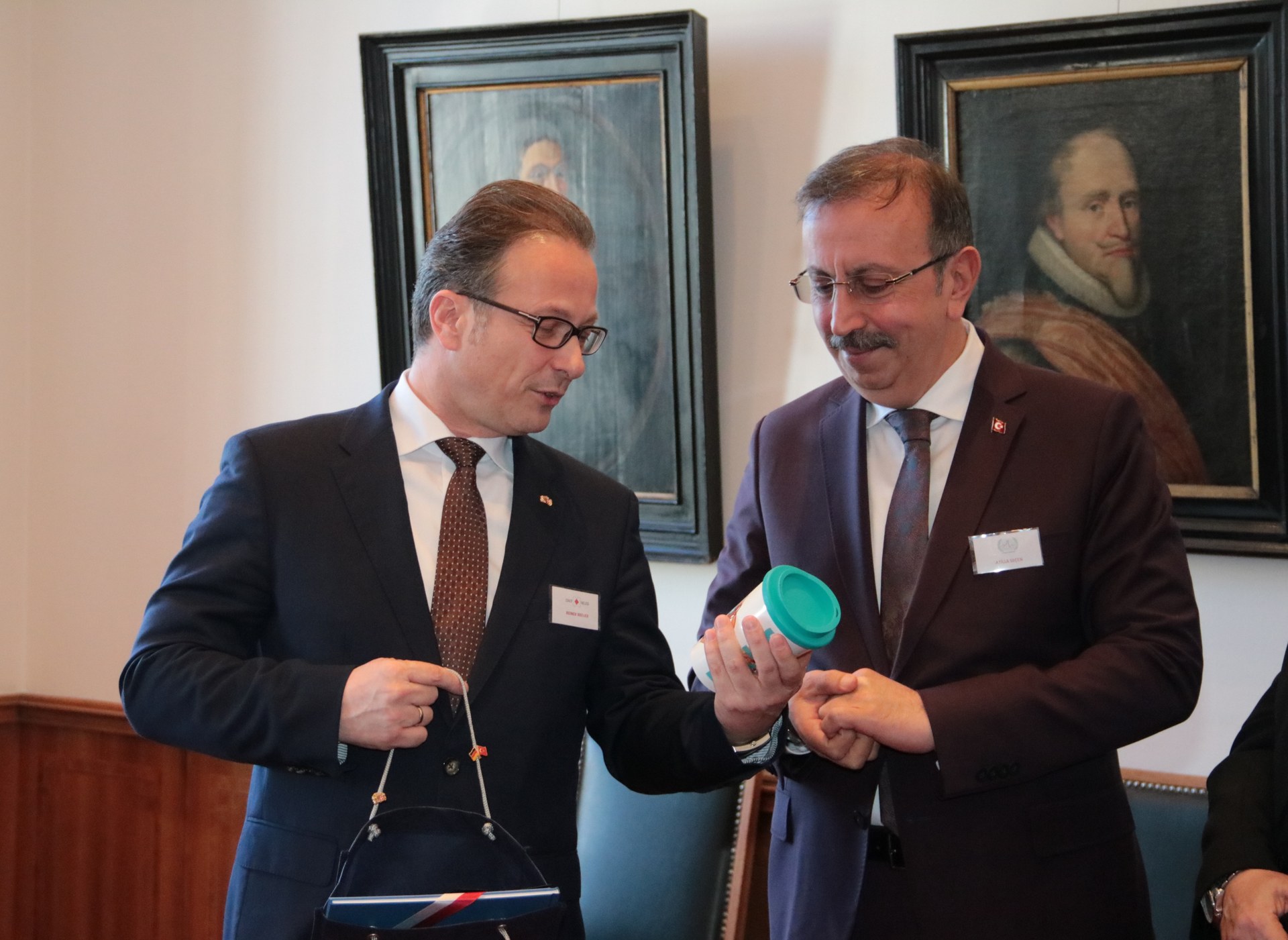 Bürgermeister Breuer zeigt Bürgermeister Seçen den umweltfreundlichen Neusser Mehrwegbecher.